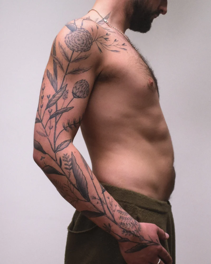 Another view of a freehand botanical tattoo across the arms