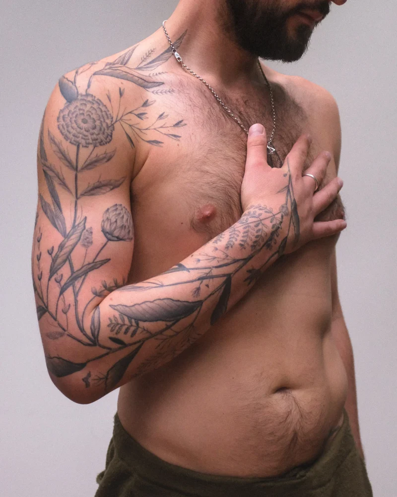 Freehand botanical tattoo across the arms