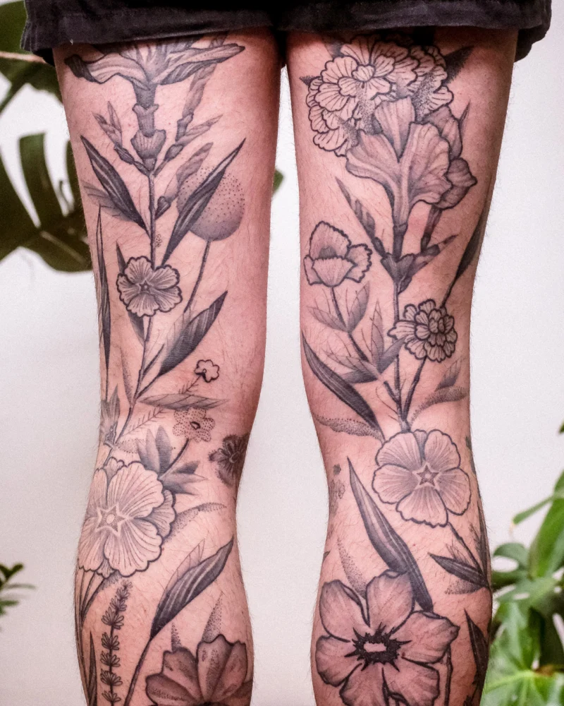 Freehand botanical tattoo across the legs