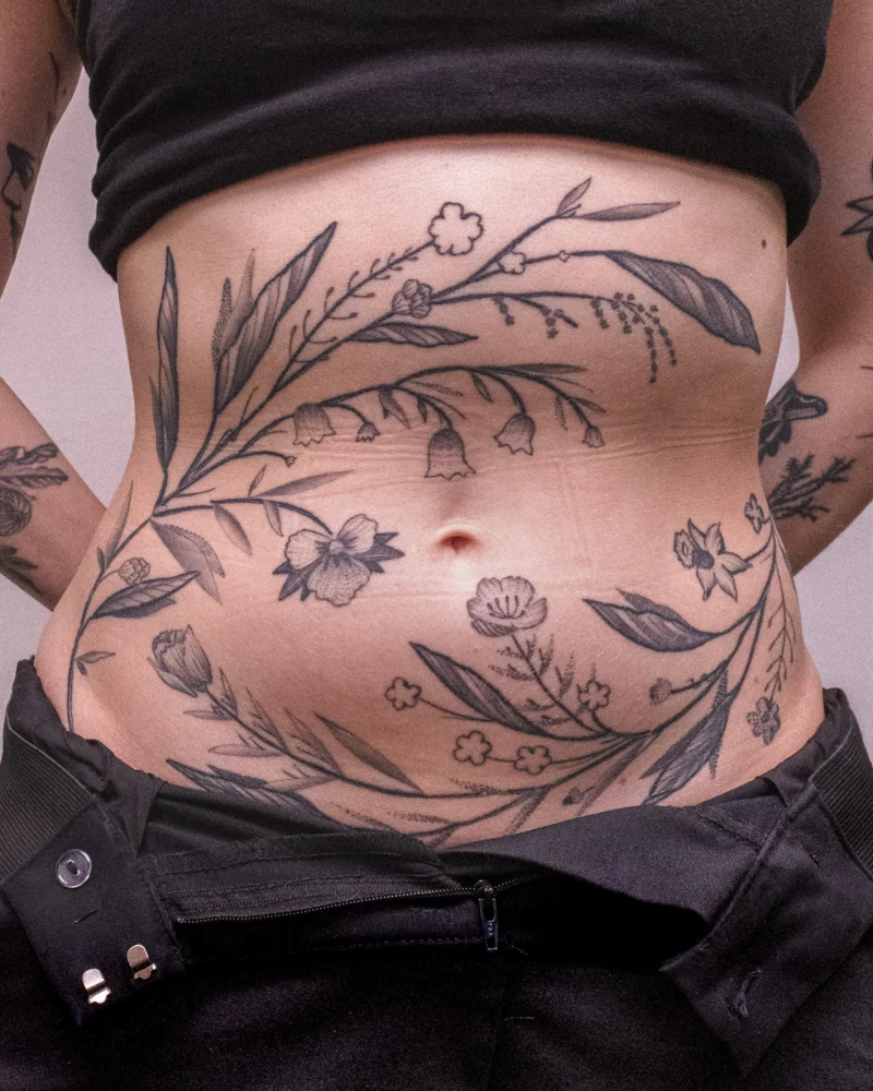 Freehand botanical tattoo across the front torso