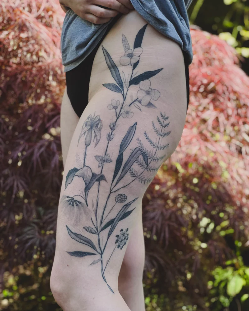 Freehand botanical tattoo across the legs