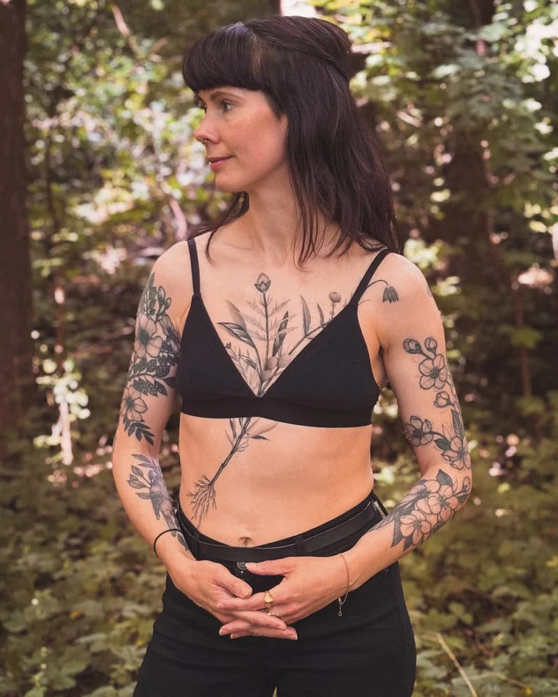 Detail view of a freehand botanical tattoo across the front torso