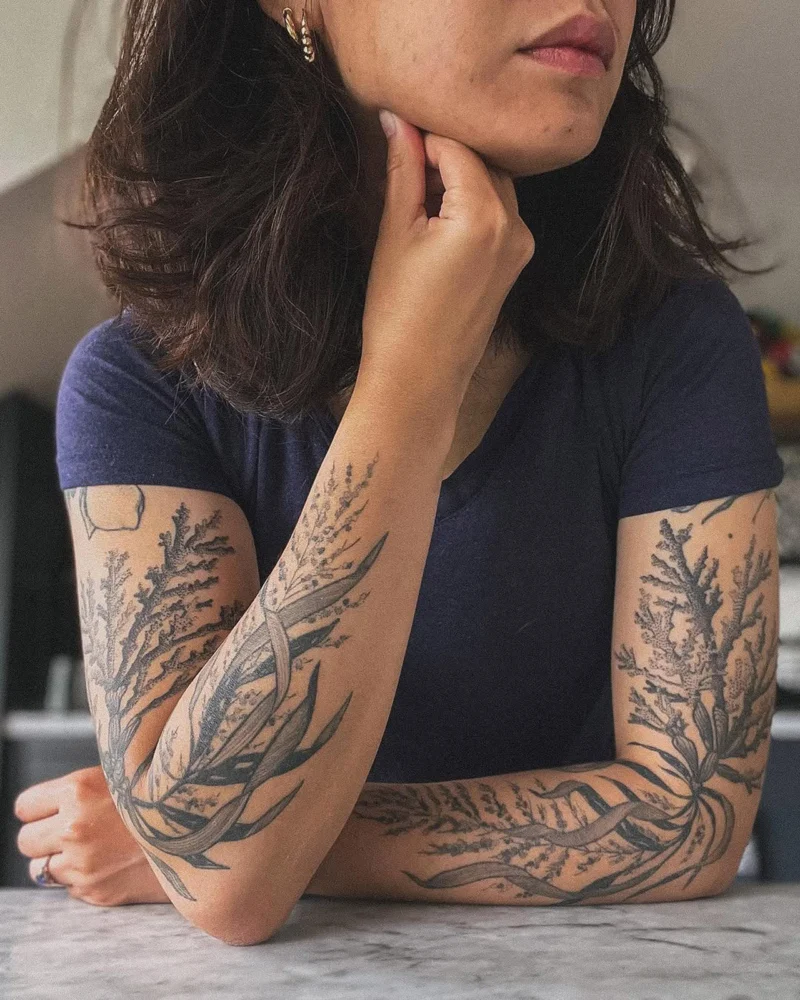 Freehand botanical tattoo across the arms